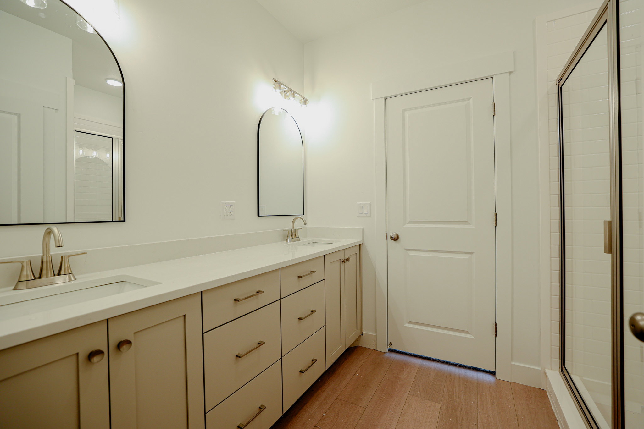 Double vanity with neutral cabinetry, light-toned countertops, and brushed nickel hardware