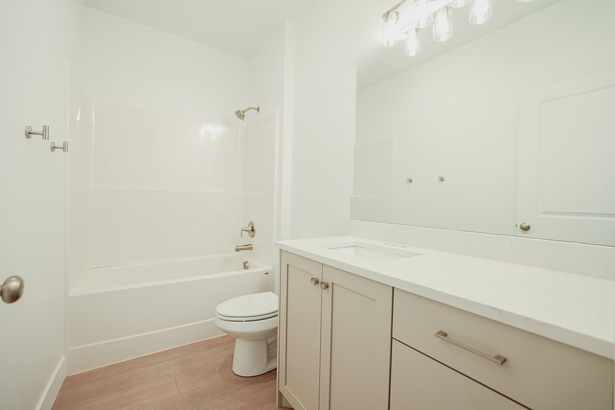 Contemporary bathroom featuring a light-toned vanity with an integrated sink, polished hardware, and a coordinating countertop