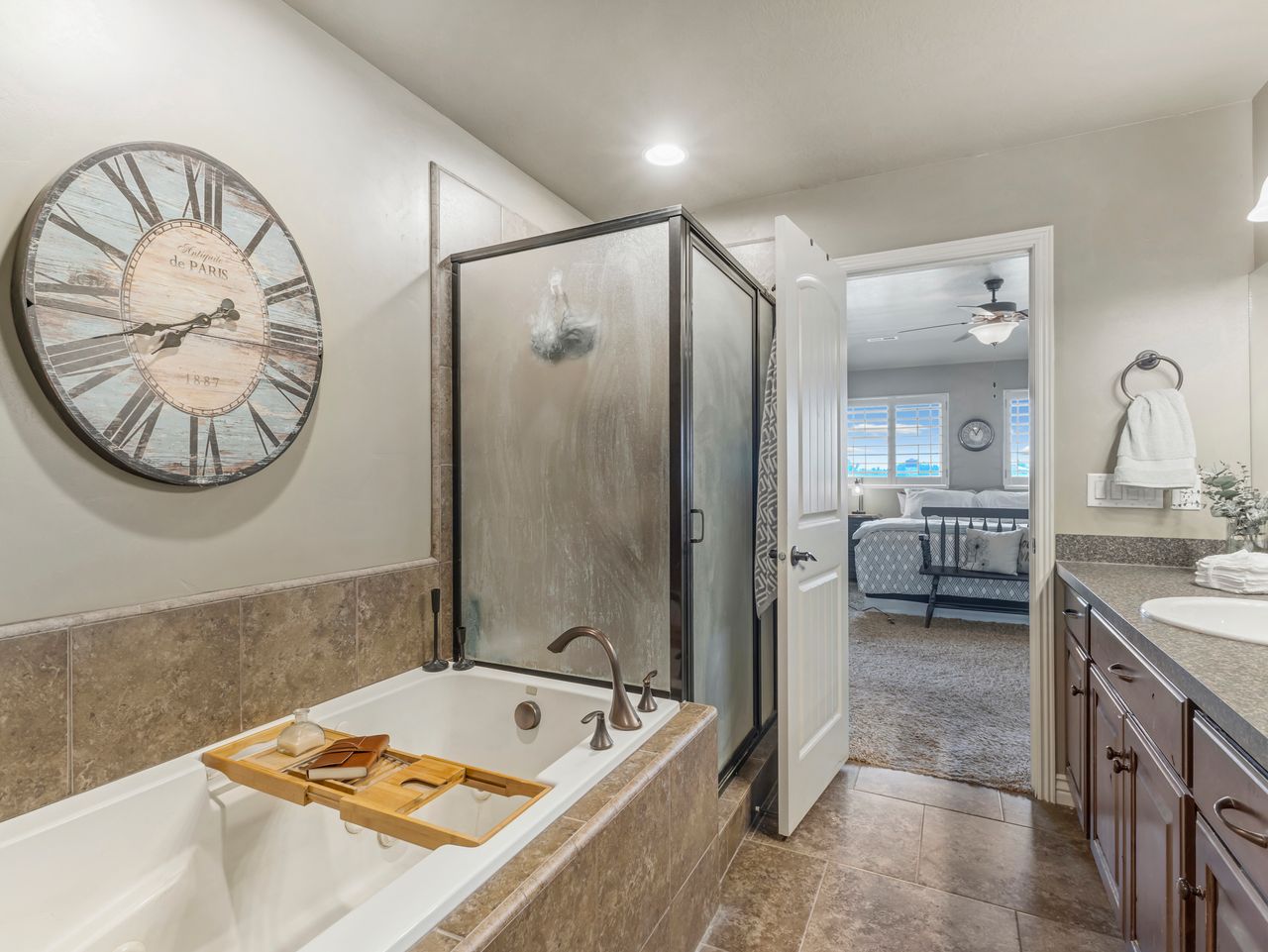 Built-in soaking tub with bronze fixtures, framed by a tiled surround