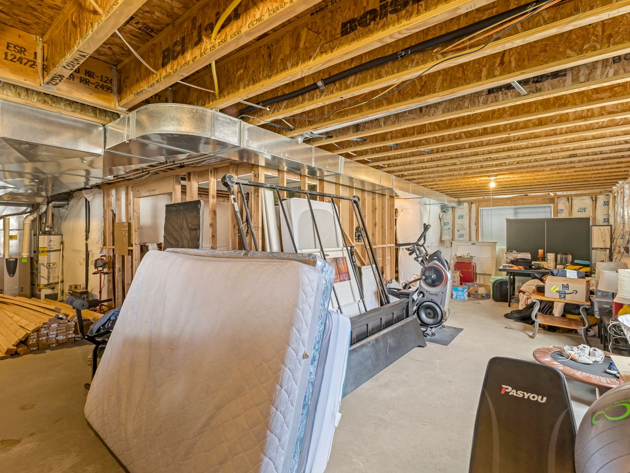Unfinished basement offering substantial expansion potential with exposed wood joists, structural framing, and visible utility systems