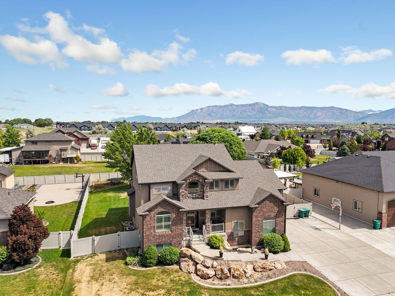 Two-story residence featuring a brick and stucco exterior with stone accents