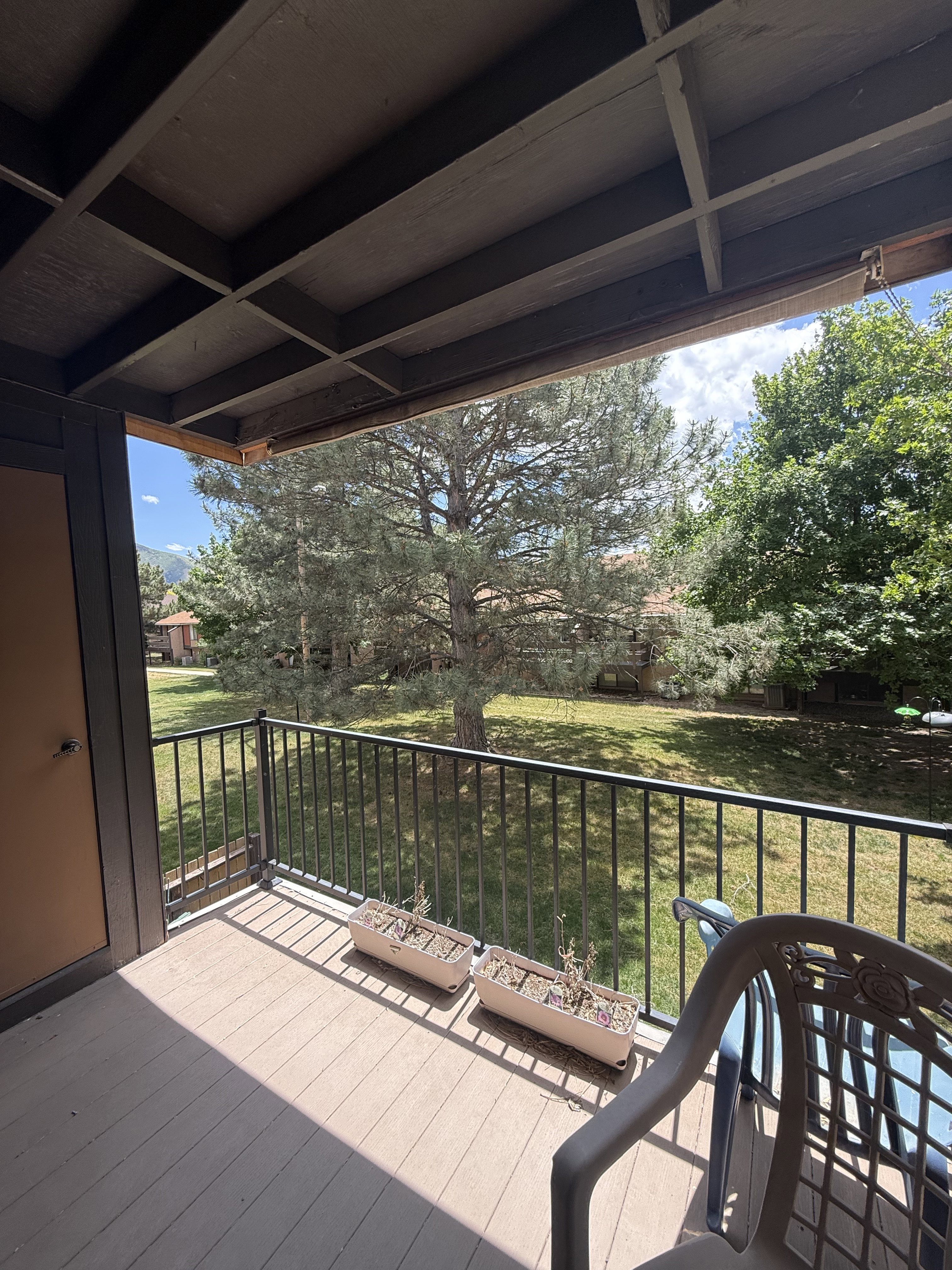 Shaded balcony with composite decking and a black metal railing