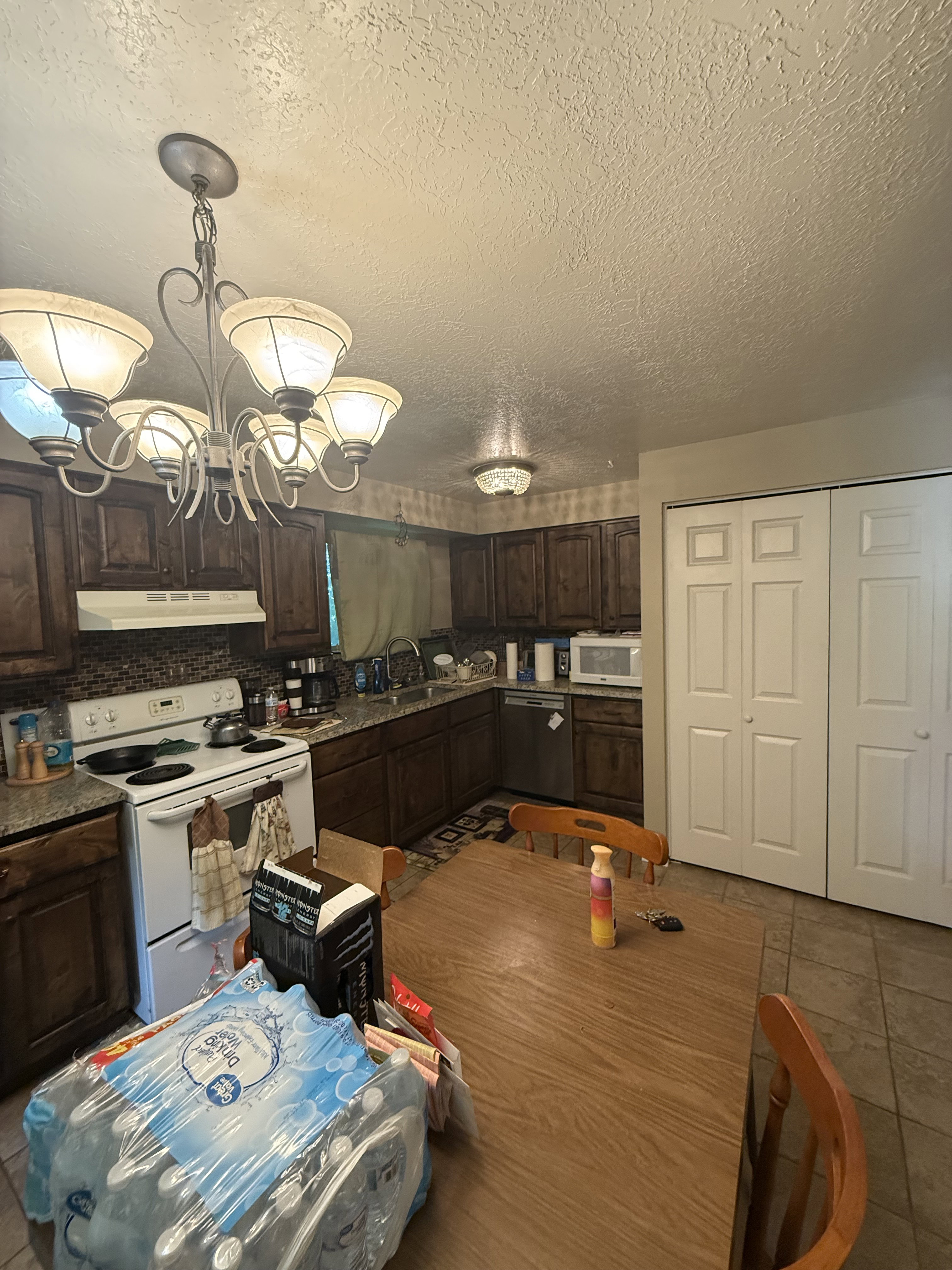 Kitchen space featuring dark wood cabinetry, a mosaic tile backsplash, and light-toned countertops