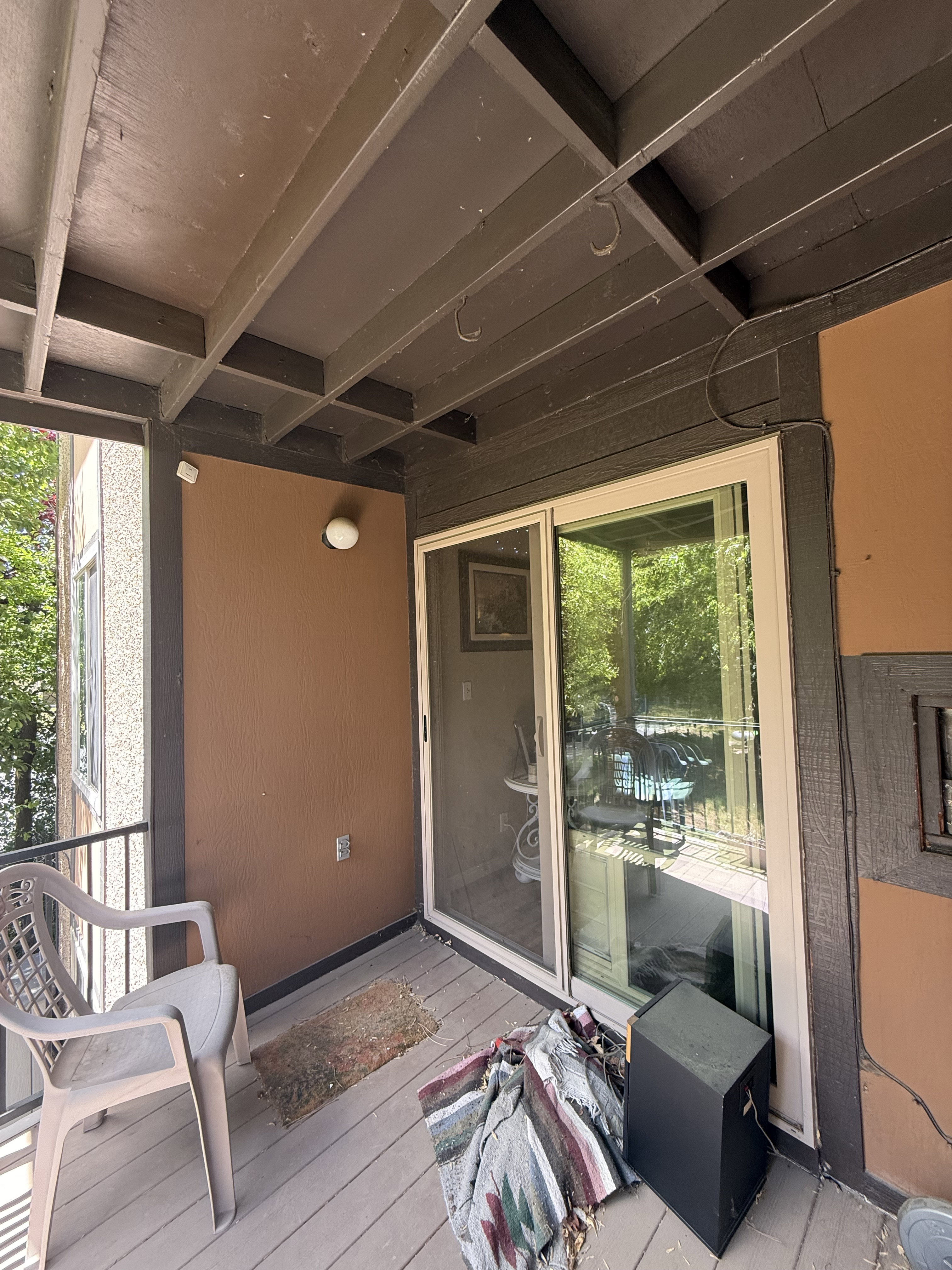Private outdoor deck featuring wood-finish flooring, a metal railing, and a wall-mounted light fixture