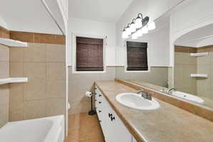 Bathroom vanity with a single basin sink, laminate countertop, and integrated mirror