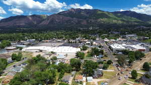Aerial perspective showcasing a developed area with extensive tree cover, commercial structures, and residential properties