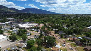 Expansive aerial perspective showcasing a residential neighborhood with surrounding commercial structures and extensive green spaces