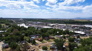 Aerial perspective showcasing a residential neighborhood with surrounding commercial districts and distant mountains
