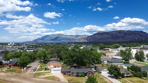 Residential neighborhood with established homes and mature trees, featuring distant mountains