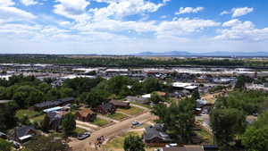 Aerial overview showcasing a residential district with distant commercial areas and mountain ranges under a clear sky