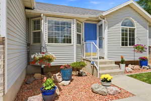 Property exterior featuring light gray siding, a prominent bay window, and a bright blue entry door