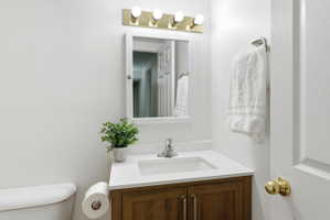 Bathroom vanity featuring a white countertop with an integrated sink, wood-finish cabinetry, and a chrome faucet