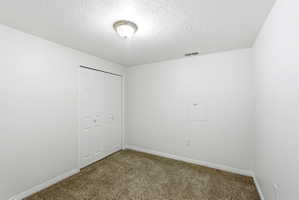 Neutral-toned wall-to-wall carpeting complements the white walls and trim