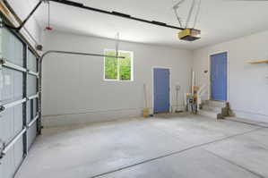 Spacious garage featuring a concrete floor, light gray walls, and an automatic garage door opener