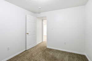 Room with neutral paint, textured ceiling, and carpeting