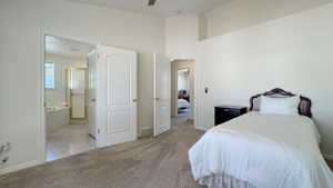 Carpeted interior space with a vaulted ceiling and white walls