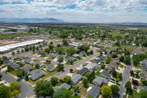 Aerial perspective showcasing a residential neighborhood with single-story homes, mature trees, and paved streets