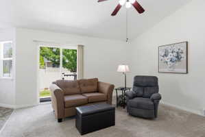 Living area featuring a vaulted ceiling and a ceiling fan