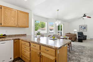 Kitchen featuring light wood cabinetry, a white dishwasher, and a laminate countertop