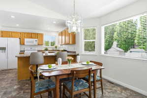 Dining area featuring a contemporary chandelier, wood-finish flooring, and ample natural light from multiple windows
