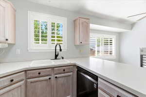 Kitchen featuring white countertops, light wood-finish cabinetry, a dual-basin sink with a matte black faucet, and white plantation shutters