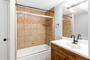 Bathroom featuring a single vanity with a white countertop and oval basin, bronze-finish faucet, and a large wall-mounted mirror