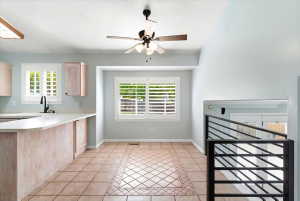 Open-concept kitchen and dining area featuring light-toned cabinetry, light countertops, and a built-in kitchen island