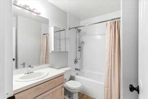 Bathroom featuring a white bathtub, subway tile surround, chrome shower fixtures, and a vanity with an integrated sink and wood-finish cabinetry