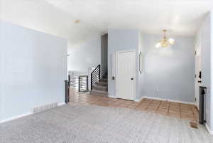Interior entry hall featuring a mix of carpet and tile flooring
