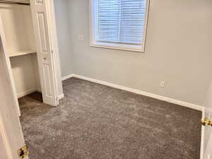 Room featuring plush carpet flooring, light-colored walls, and white baseboards