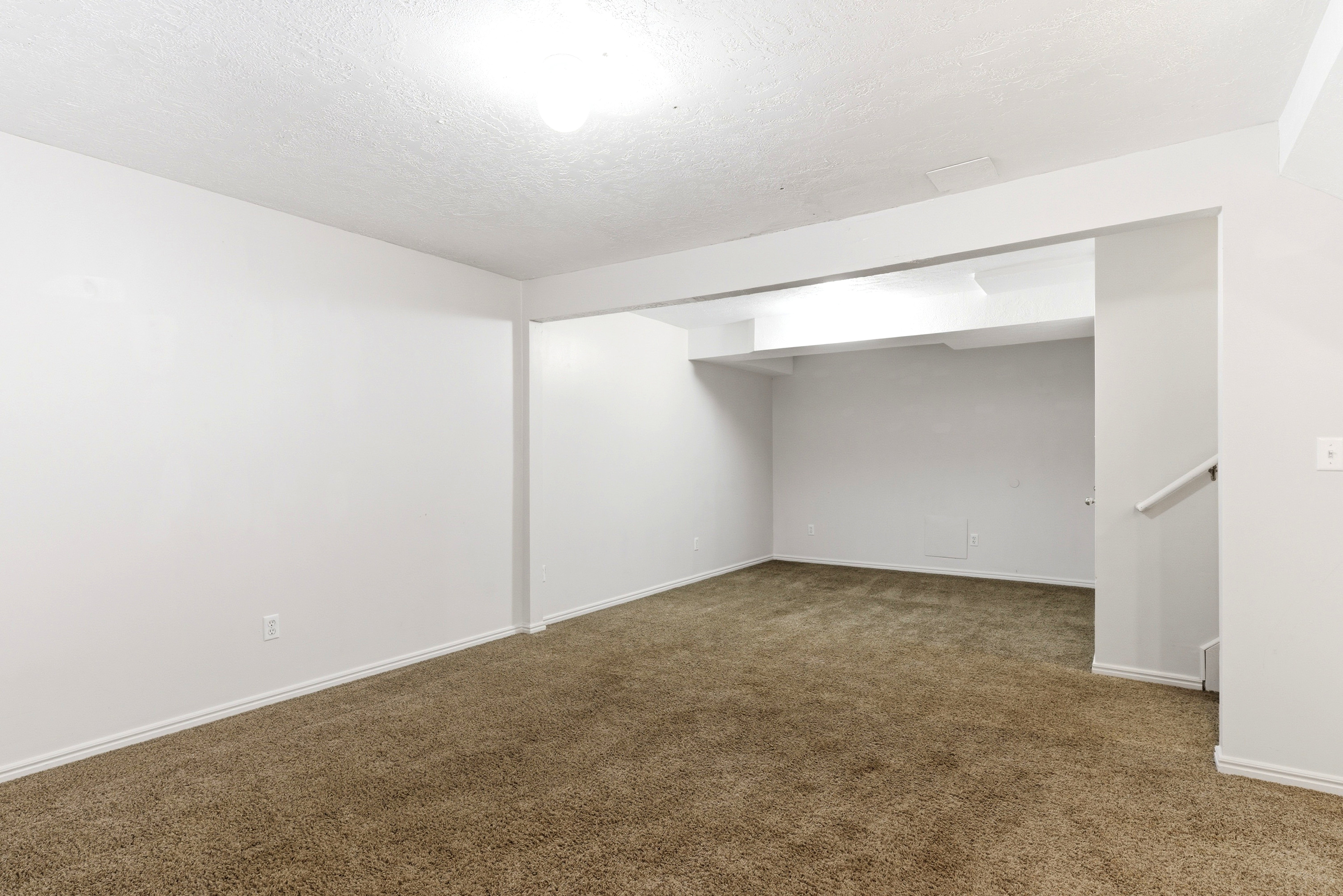 Carpeted room featuring white walls, white trim, and a ceiling-mounted light fixture