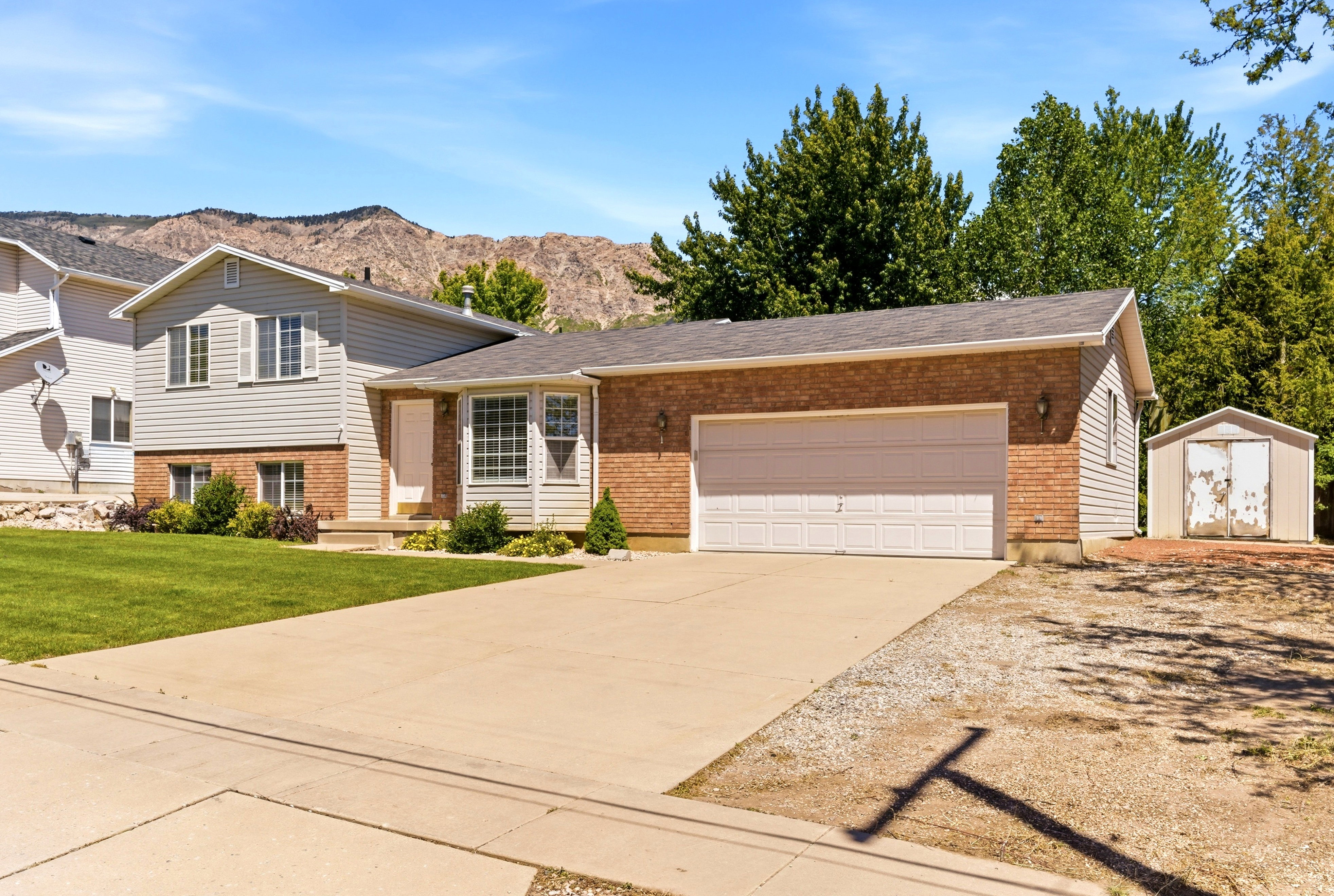 Two-story residence featuring brick and siding exterior, an attached two-car garage, and a concrete driveway
