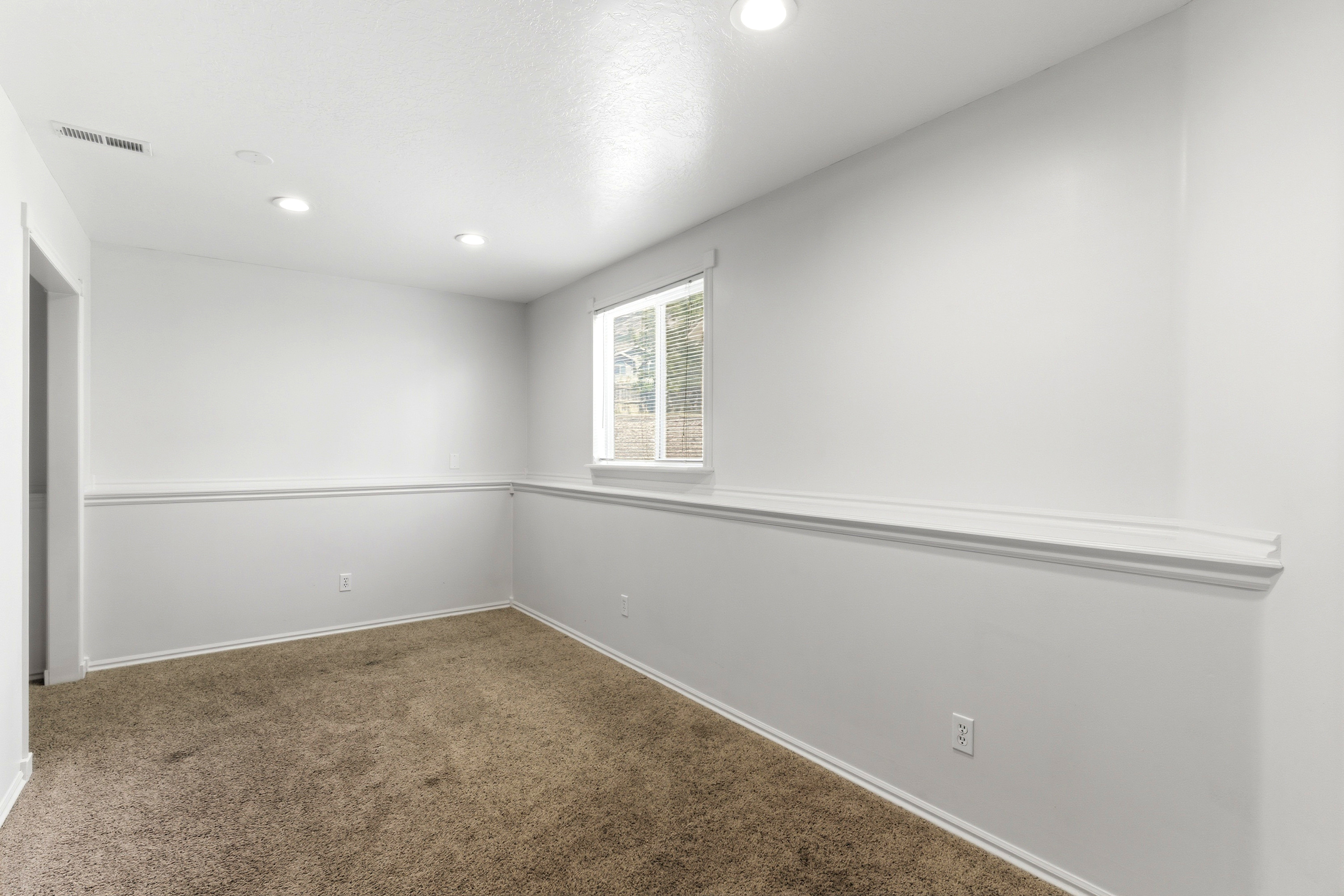 Carpeted room featuring a white interior, recessed lighting, and a single window