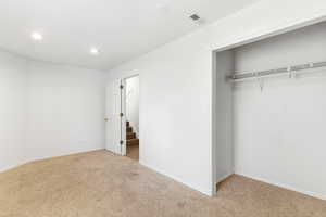 Neutral wall finishes with recessed lighting and carpeted flooring
