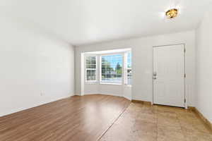 Entryway featuring a white paneled door, flush-mount lighting, and a bay window