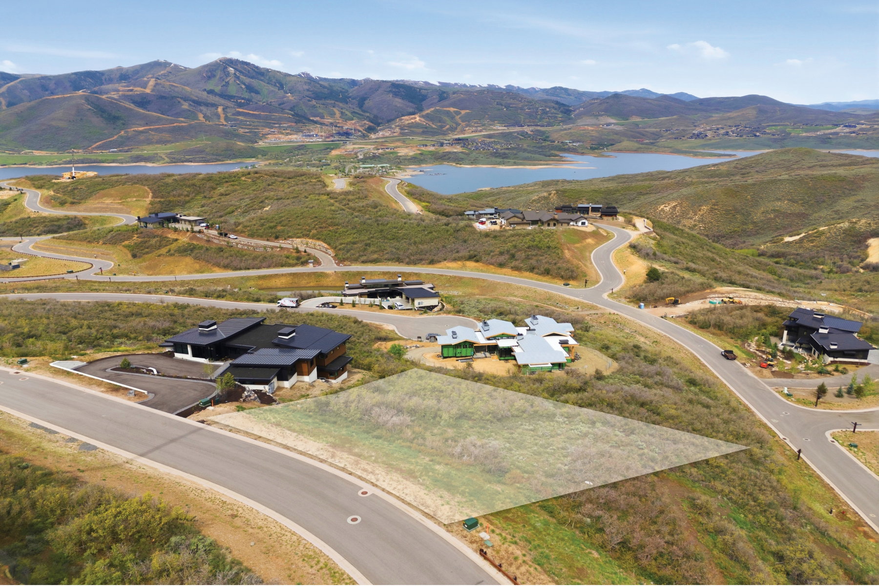 Expansive lot featuring a sloped terrain, paved road frontage, and surrounding natural foliage