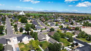 Aerial perspective showcasing a residential neighborhood with detached homes, mature trees, and paved streets
