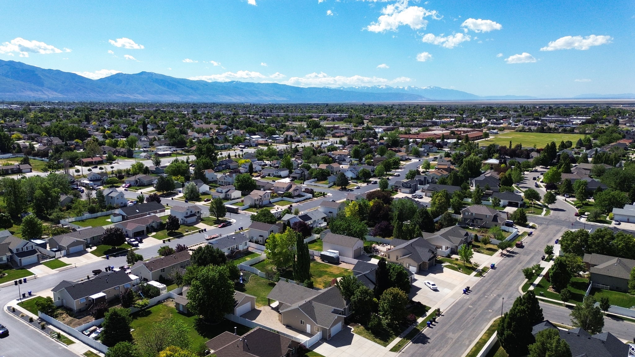Residential neighborhood featuring a grid-pattern street layout, mature trees, and individual single-family homes with pitched roofs
