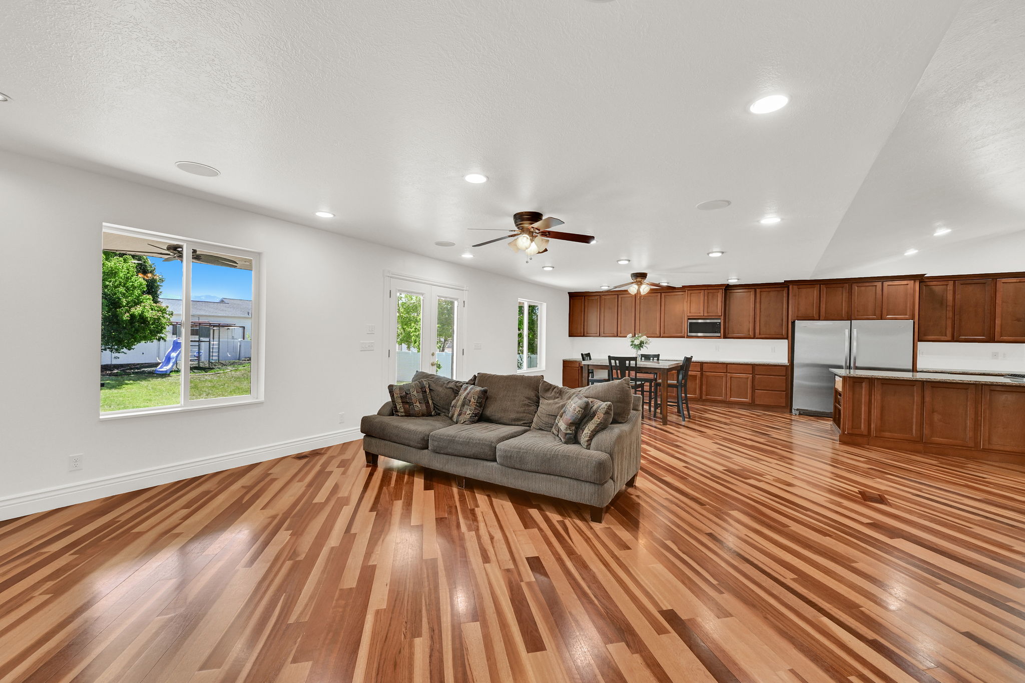 Spacious interior featuring wood-finish flooring, recessed lighting, and a kitchen with wood cabinetry