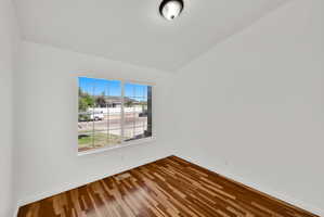 Bright room with wood-finish flooring, white walls, and a multi-pane window