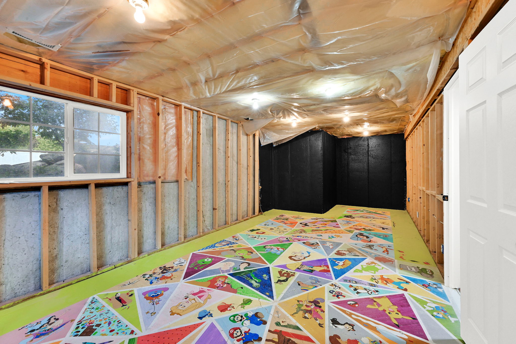Unfinished basement space featuring exposed wood framing, concrete foundation walls, and a white-framed window