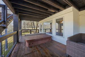 Expansive wood-finish deck featuring a built-in hot tub