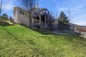 Terraced lawn leading to a multi-level deck structure with exterior stairs
