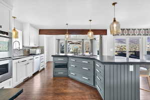 Expansive kitchen with a large multi-level island featuring a built-in microwave and gas cooktop