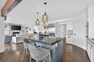 Spacious kitchen island with dark countertop and pendant lighting