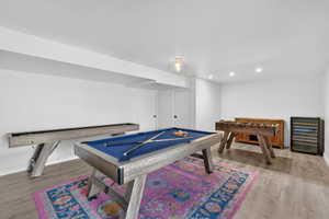 Spacious recreation area featuring wood-finish flooring and recessed lighting