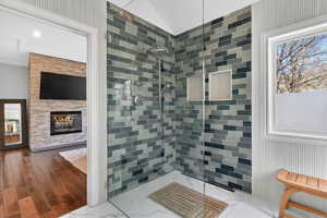 Glass-enclosed shower featuring multi-toned subway tile, dual recessed niches, and a rainfall showerhead