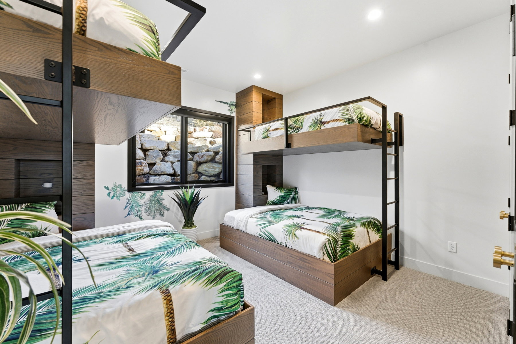 Room featuring two built-in bunk bed structures with wood-finish frames and black metal accents