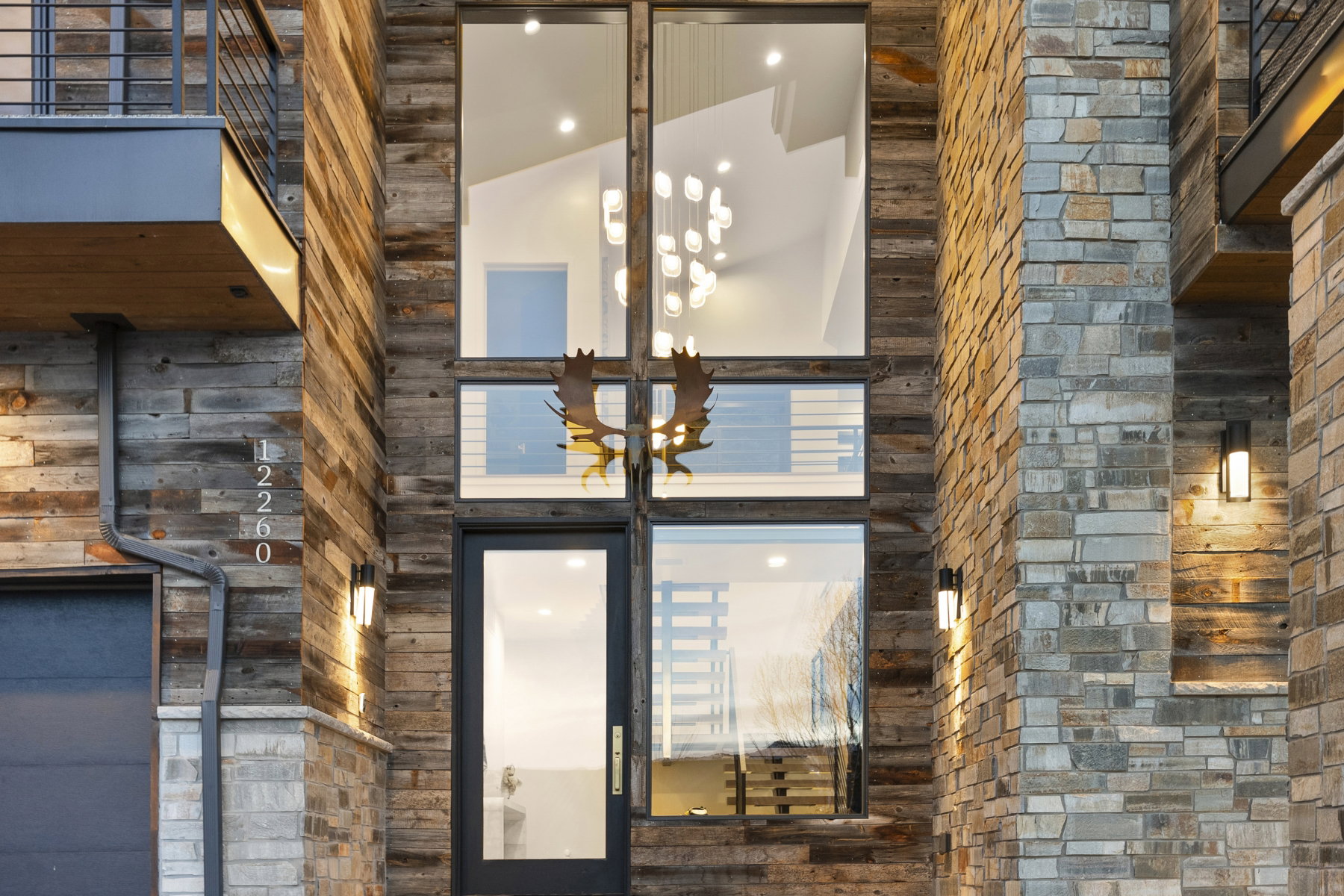 Modern architectural facade featuring stacked stone and wood-finish siding
