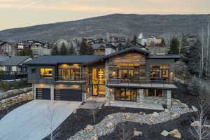 Modern mountain home featuring extensive stone and wood-finish siding